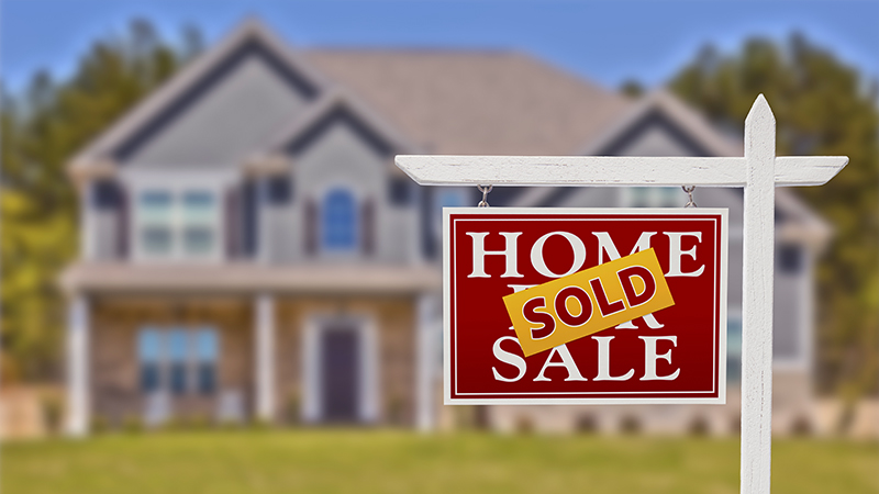 For Sale Real Estate Sign in Front of Beautiful New House after receiving home inspection services